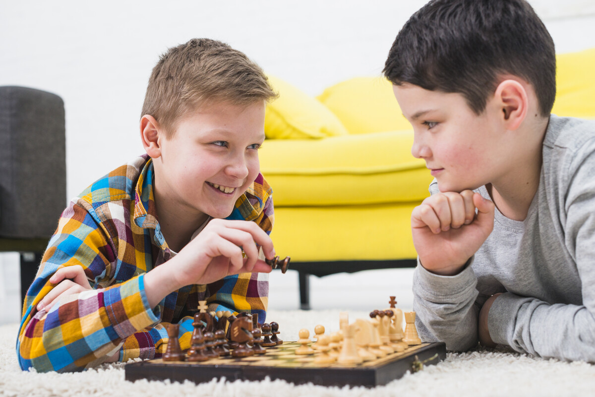 The boy playing chess. Шахматы для детей. Мальчик играет в шахматы. Дети играют в шахматы. Мальчик играет в шахматы с папой.